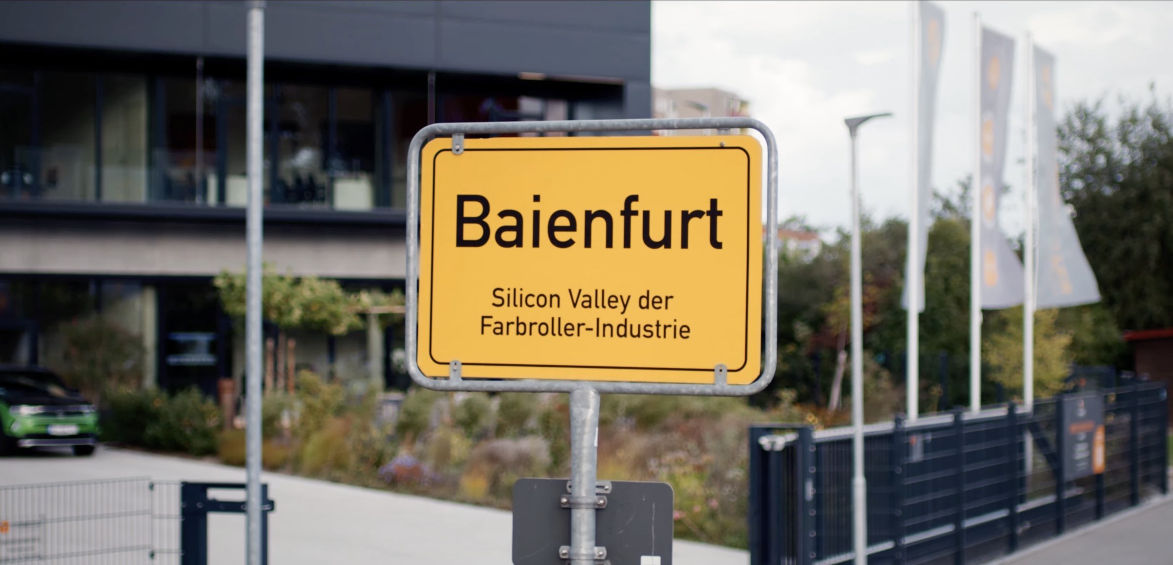 Standbild aus 'Der Perfekte Farbroller' - Ortseingangsschild 'Baienfurt · Silicon Valley der Farbroller-Industrie'